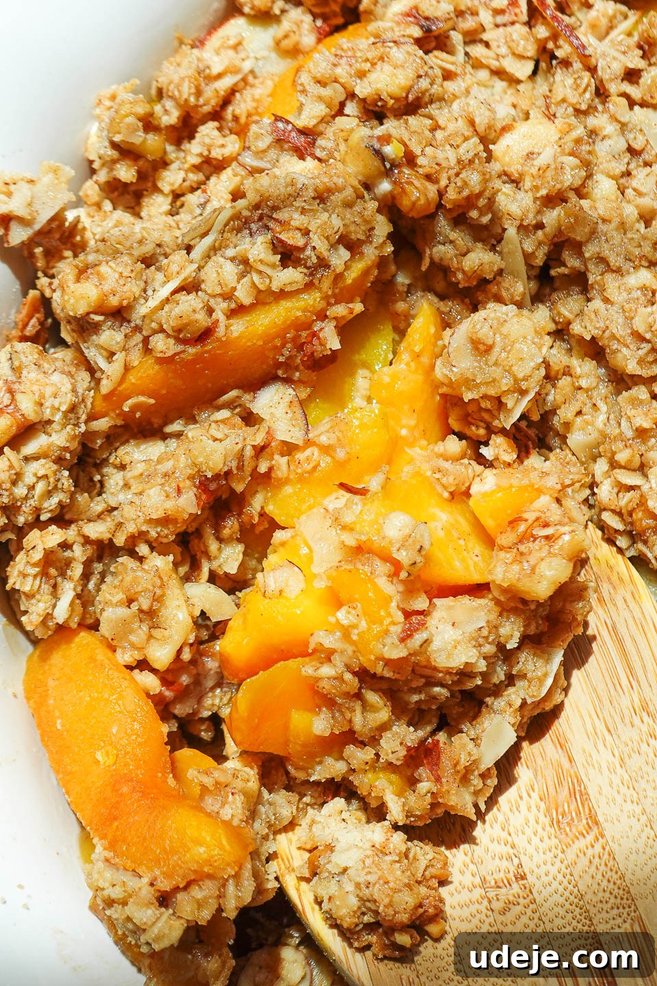 Wholesome Peach Crumble 5 A freshly baked peach crisp, showcasing bubbling fruit juices and a beautifully golden-brown, invitingly crunchy topping.