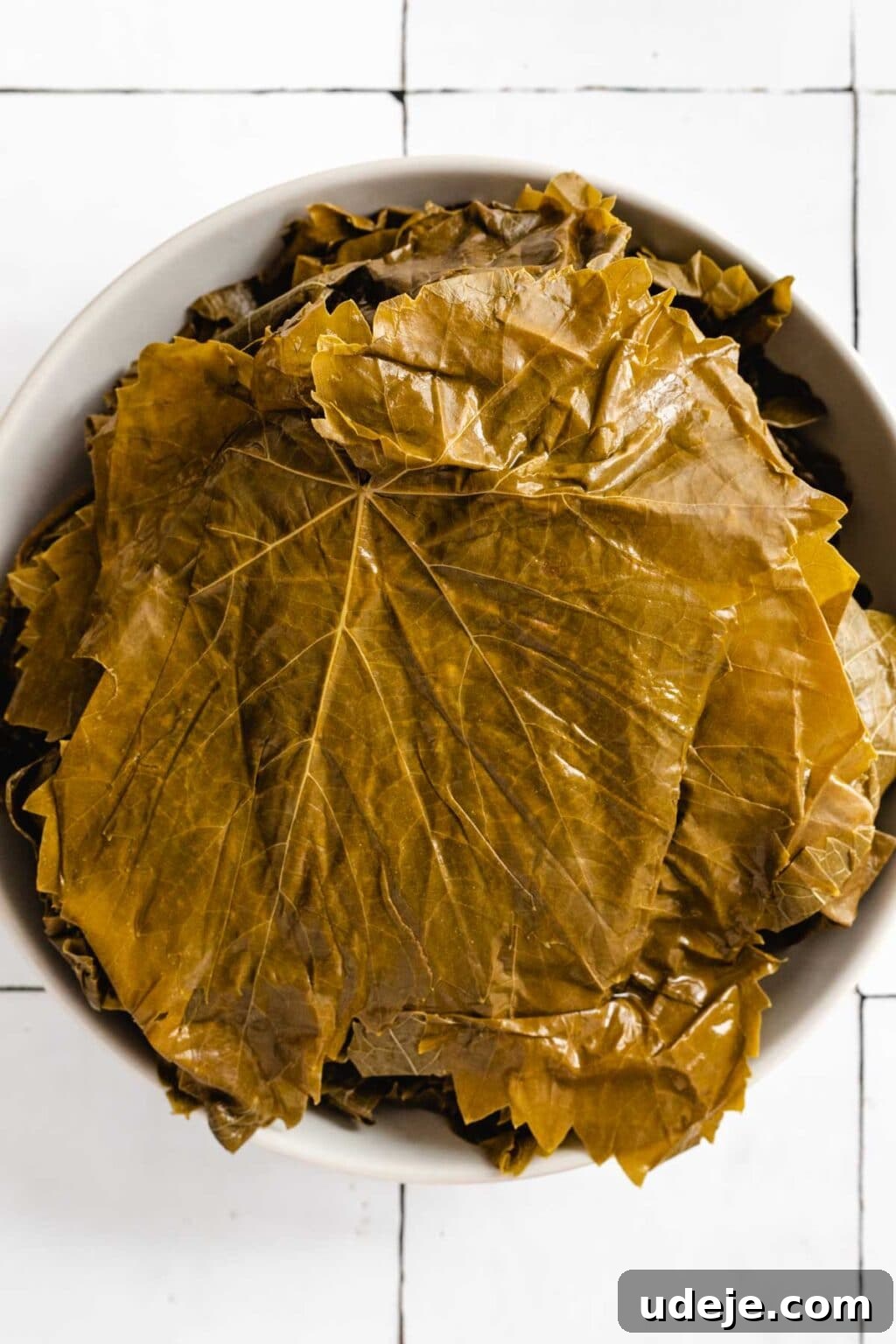 Authentic Yalanji Vegetarian Stuffed Grape Leaves 4 Washed grape leaves carefully arranged on a plate, ready for stuffing.
