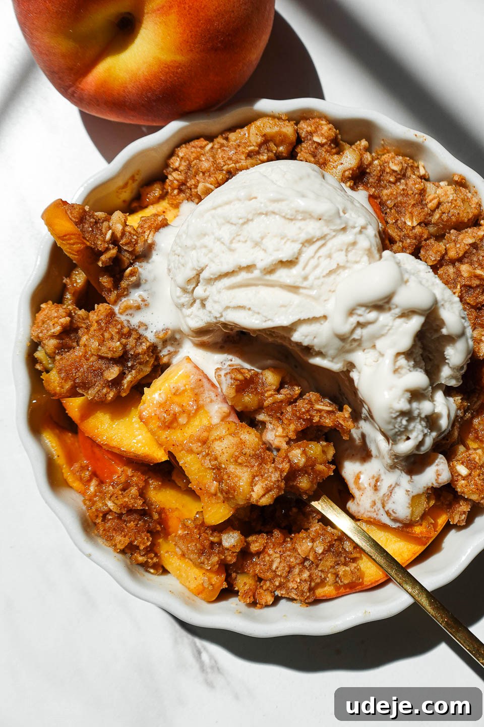 Healthy Vegan Gluten-Free Peach Crisp For One 2 Single serve healthy peach crisp in a white ramekin topped with golden oat-nut crumble