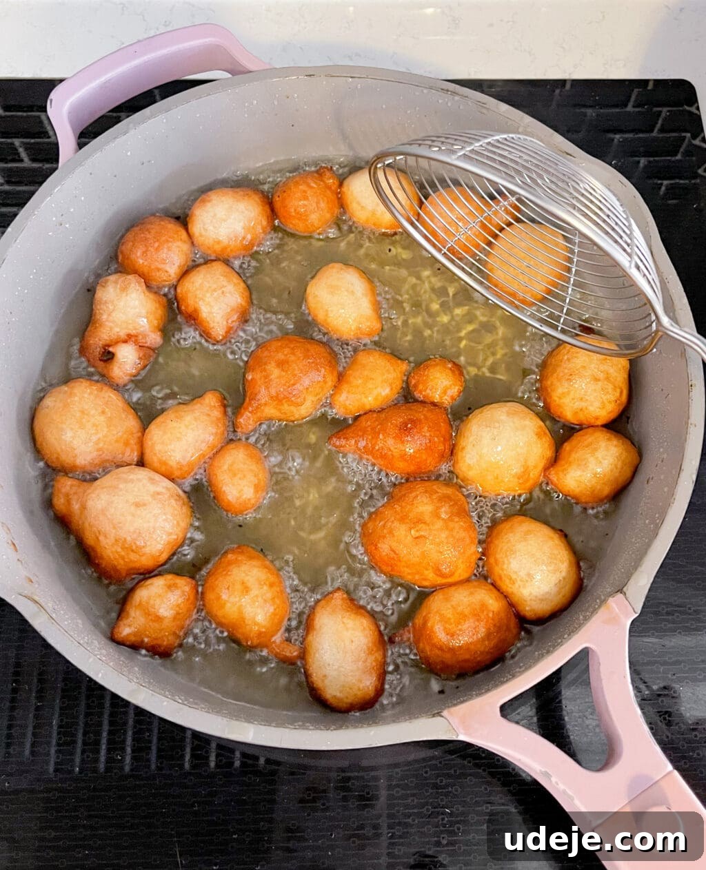 Crunchy Middle Eastern Luqaimat and Awamat Fritters 7 Crispy Luqaimat fritters sizzle in a pan filled with hot, bubbling oil, demonstrating the crucial frying stage of this beloved Middle Eastern dessert.
