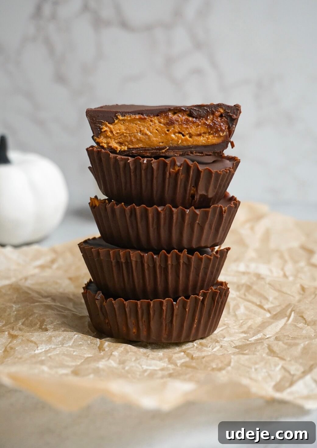 Autumn Peanut Butter Pumpkin Delights 3 All 7 simple ingredients for Pumpkin Peanut Butter Cups displayed on a rustic background.