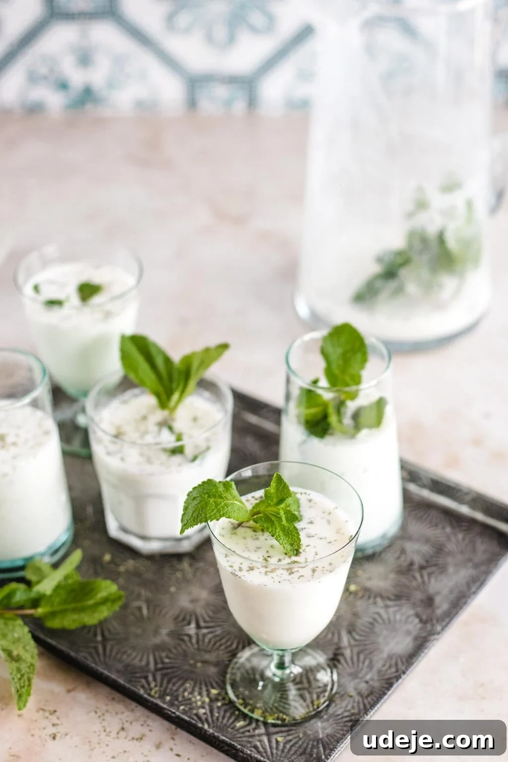 Whip Up Refreshing Turkish Ayran in Just 5 Minutes 5 Several clear glasses filled with Ayran, a yogurt and mint drink popular in Turkey, placed on a silver tray.