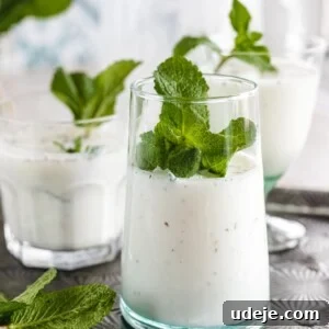 Whip Up Refreshing Turkish Ayran in Just 5 Minutes 6 Several clear glasses filled with Ayran, a yogurt and mint drink, placed on a silver tray and topped with fresh mint.