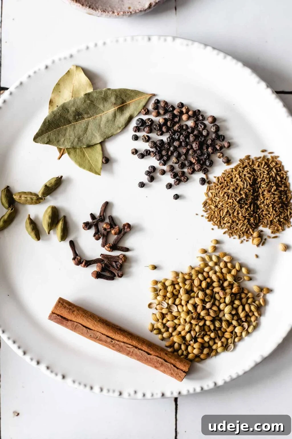 Yemeni Chicken Mandi with Fragrant Spiced Rice 3 Spice blend for chicken prepped on white ceramic plate, featuring an array of whole spices for Hawaij.