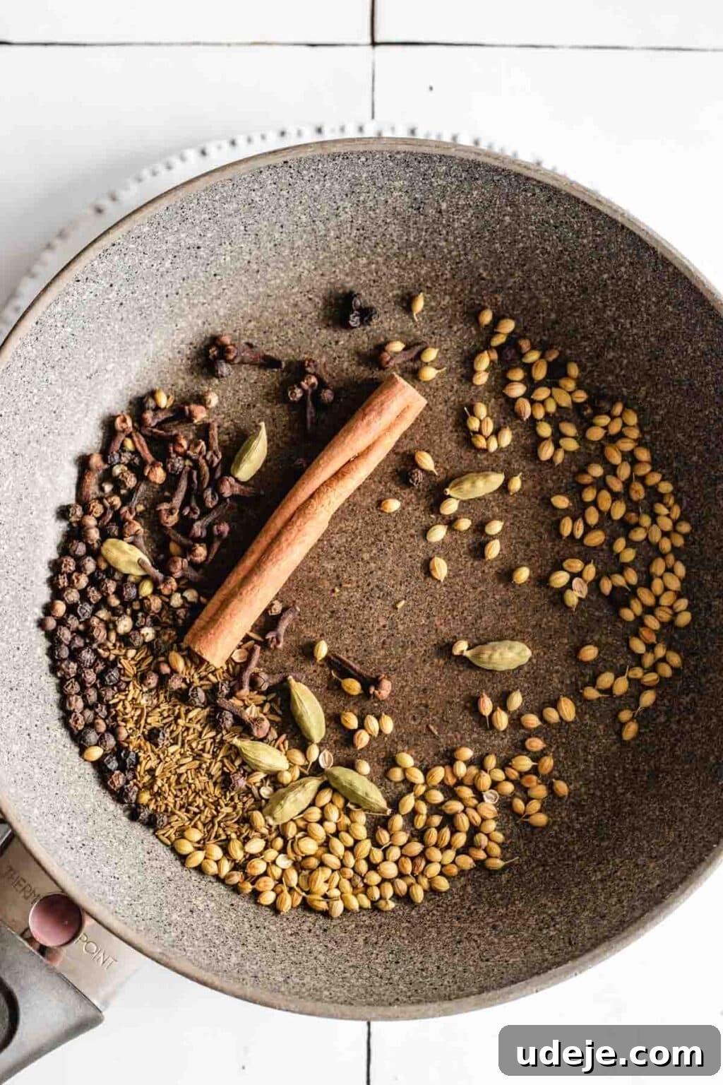 Yemeni Chicken Mandi with Fragrant Spiced Rice 5 A collection of whole spices for chicken mandi in a brown bowl, including a cinnamon stick, cloves, coriander, black pepper, cardamom and cumin.