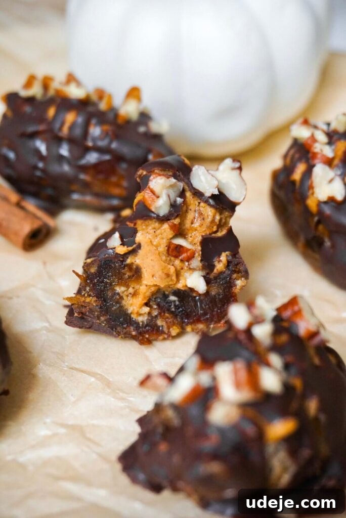 Pumpkin Spice Date Poppers 3 Close-up of a Pumpkin Stuffed Date featuring a creamy pumpkin and nut butter filling, rich chocolate drizzle, and crunchy pecan topping, highlighting the texture and appeal of this autumn dessert.