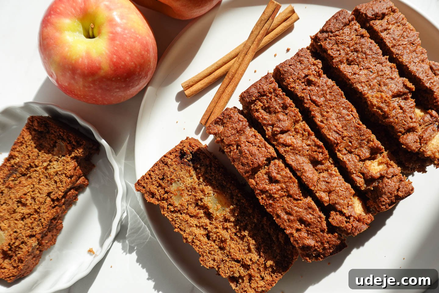 Wholesome Vegan Gluten-Free Apple Bread 2 Healthy apple bread sliced on a plate with fresh apples in the background, exuding autumn charm