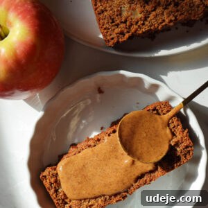 Slice of vegan apple bread served with almond butter on a plate