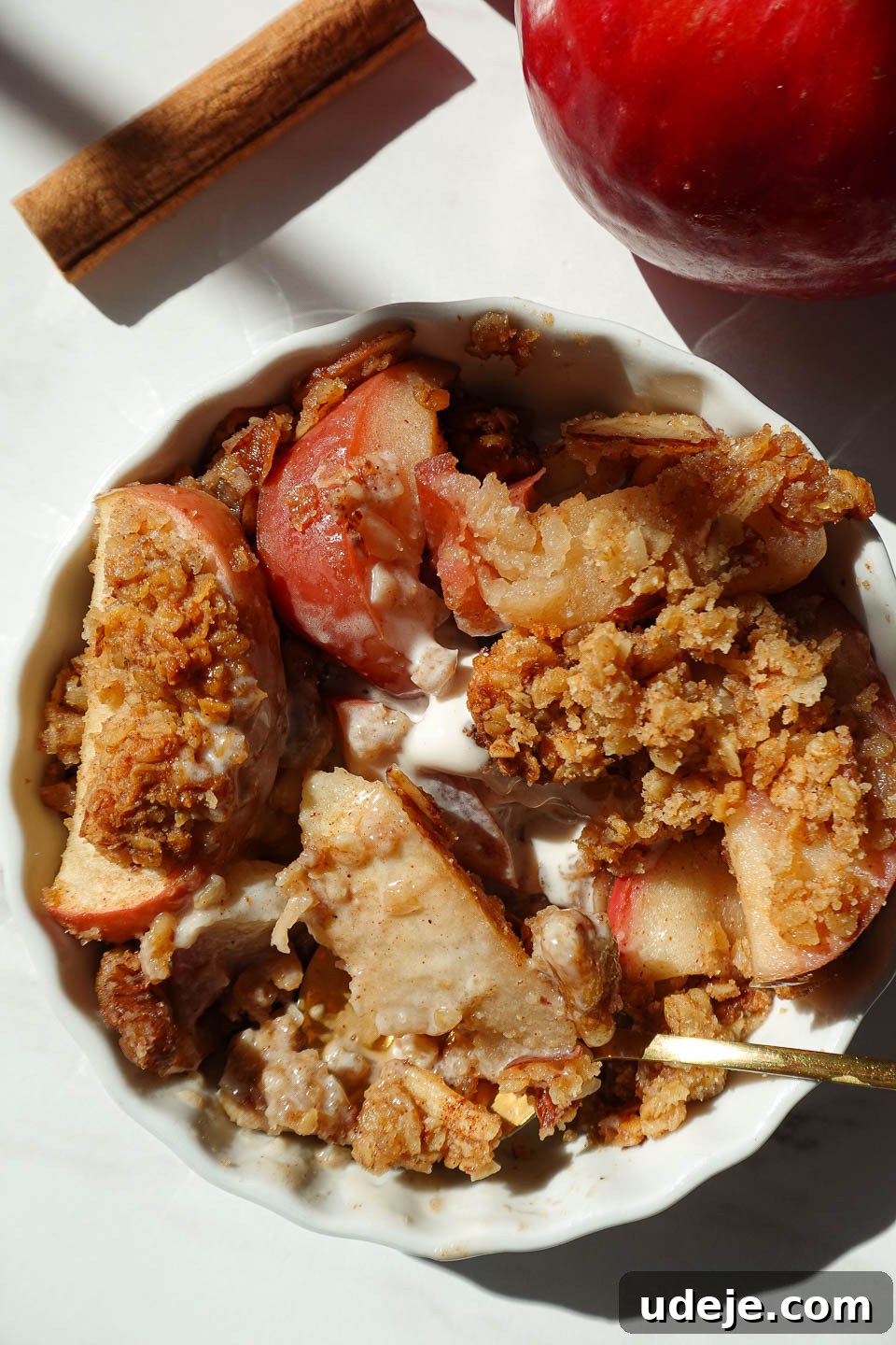 Wholesome Solo Apple Crumble 2 Single serve healthy apple crisp in a white ramekin topped with golden oat and nut crumble, served warm with a scoop of vegan vanilla ice cream.