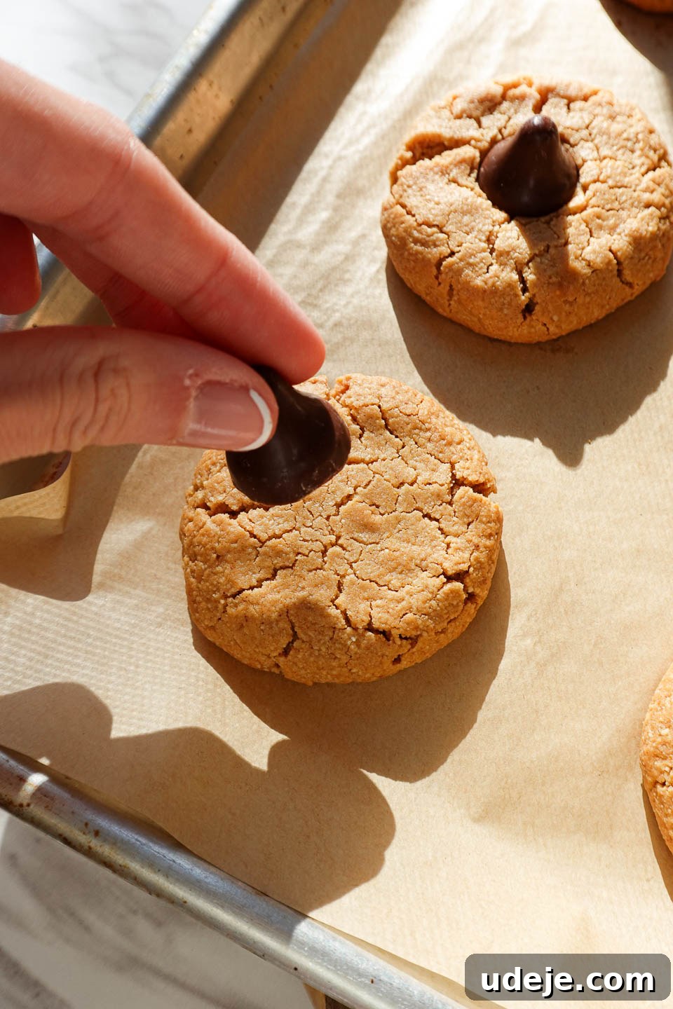 Healthy Vegan Gluten-Free Peanut Butter Blossoms 8 placing vegan chocolate kiss on peanut butter blossom