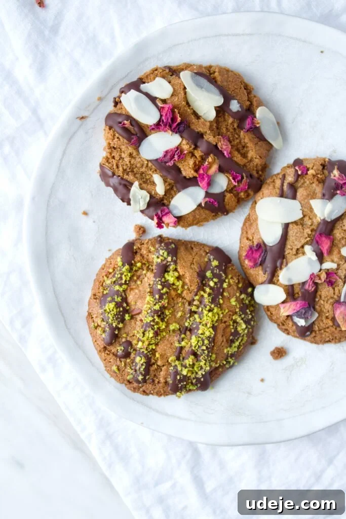 Decadent Gluten Free Double Almond Delights 4 Stack of gluten-free almond cookies drizzled with chocolate and topped with nuts.