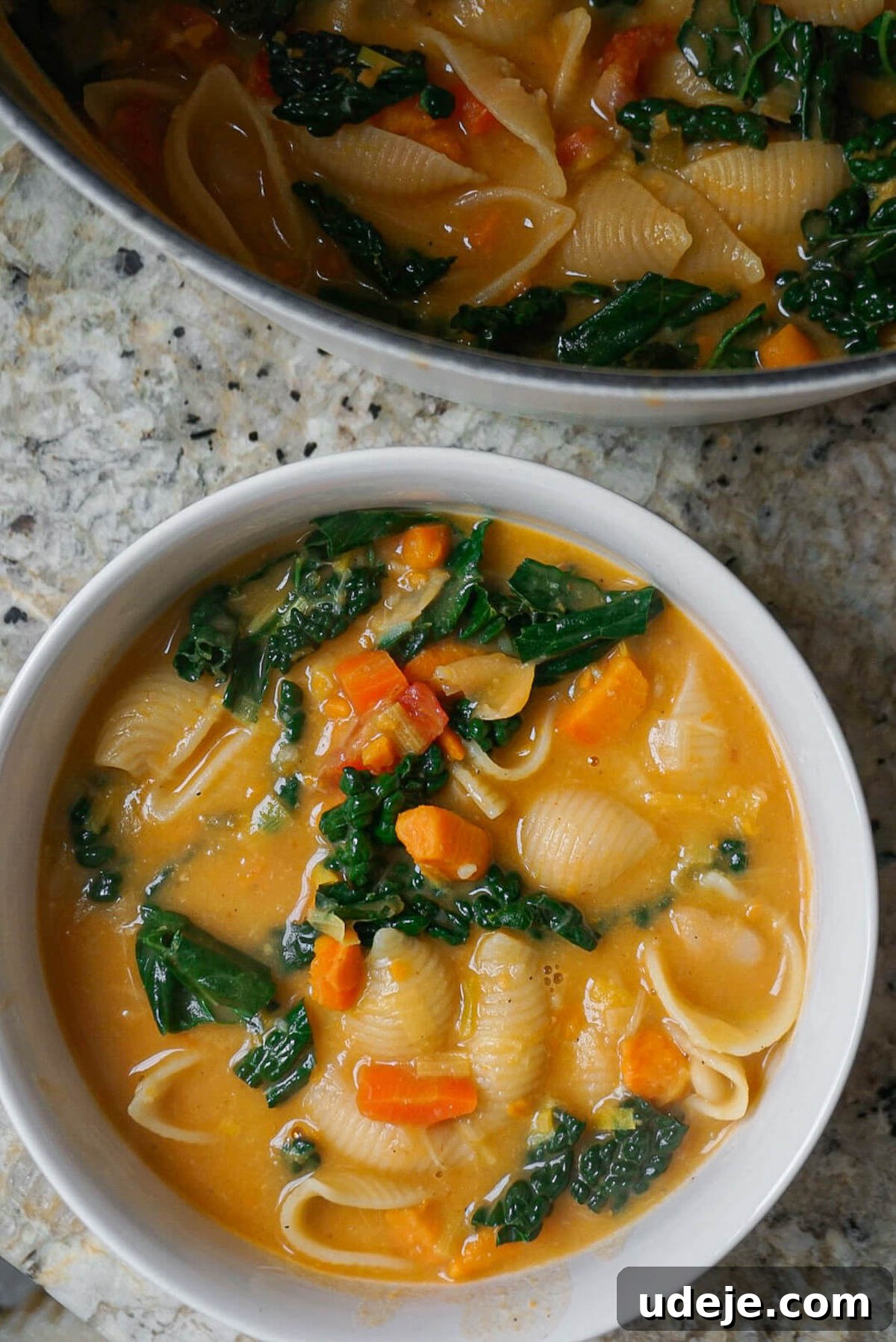 Velvety Tuscan Plant-Based Soup 4 A close-up shot of the Creamy Vegan Tuscan Soup in a Dutch oven after kale and lemon have been added, showing the rich, thick broth and perfectly cooked pasta, ready to be served.