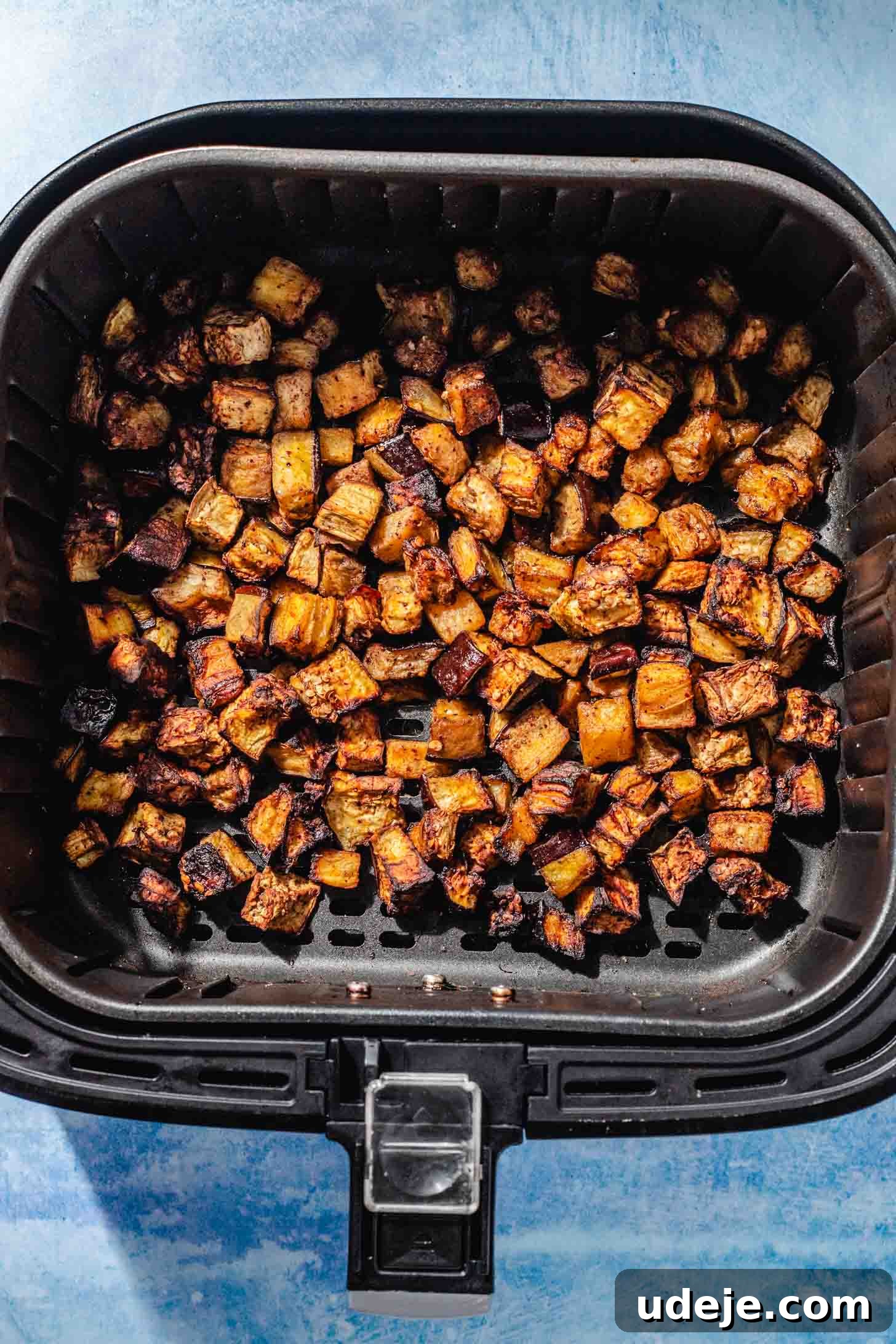 Mediterranean Eggplant Fatteh Delight 5 Perfectly roasted eggplant cubes, golden and soft, in the basket of an air fryer.