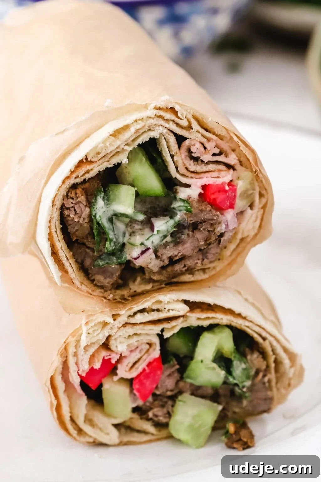 Effortless Skillet Tender Beef Shawarma 12 beef shawarma wrap in pita bread with cucumbers, pink pickles, tahini sauce and parsley
