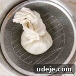 steel bowl with strainer with labneh tied in cheesecloth
