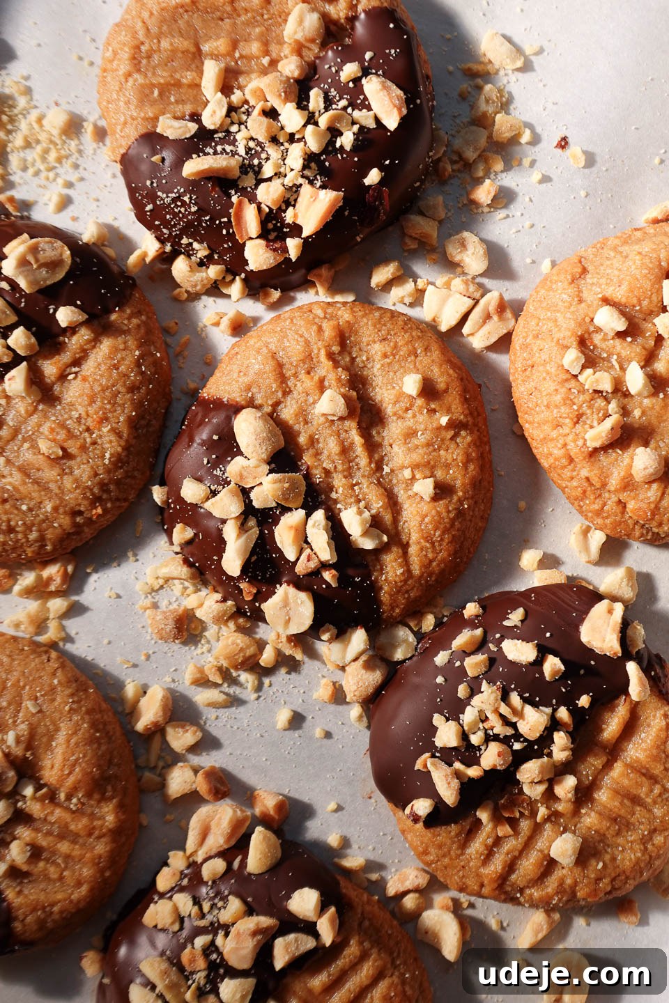 Simple Three Ingredient Vegan Gluten Free Peanut Butter Cookies 2 Overhead view of 3-ingredient peanut butter cookies half dipped in chocolate and sprinkled with chopped peanuts