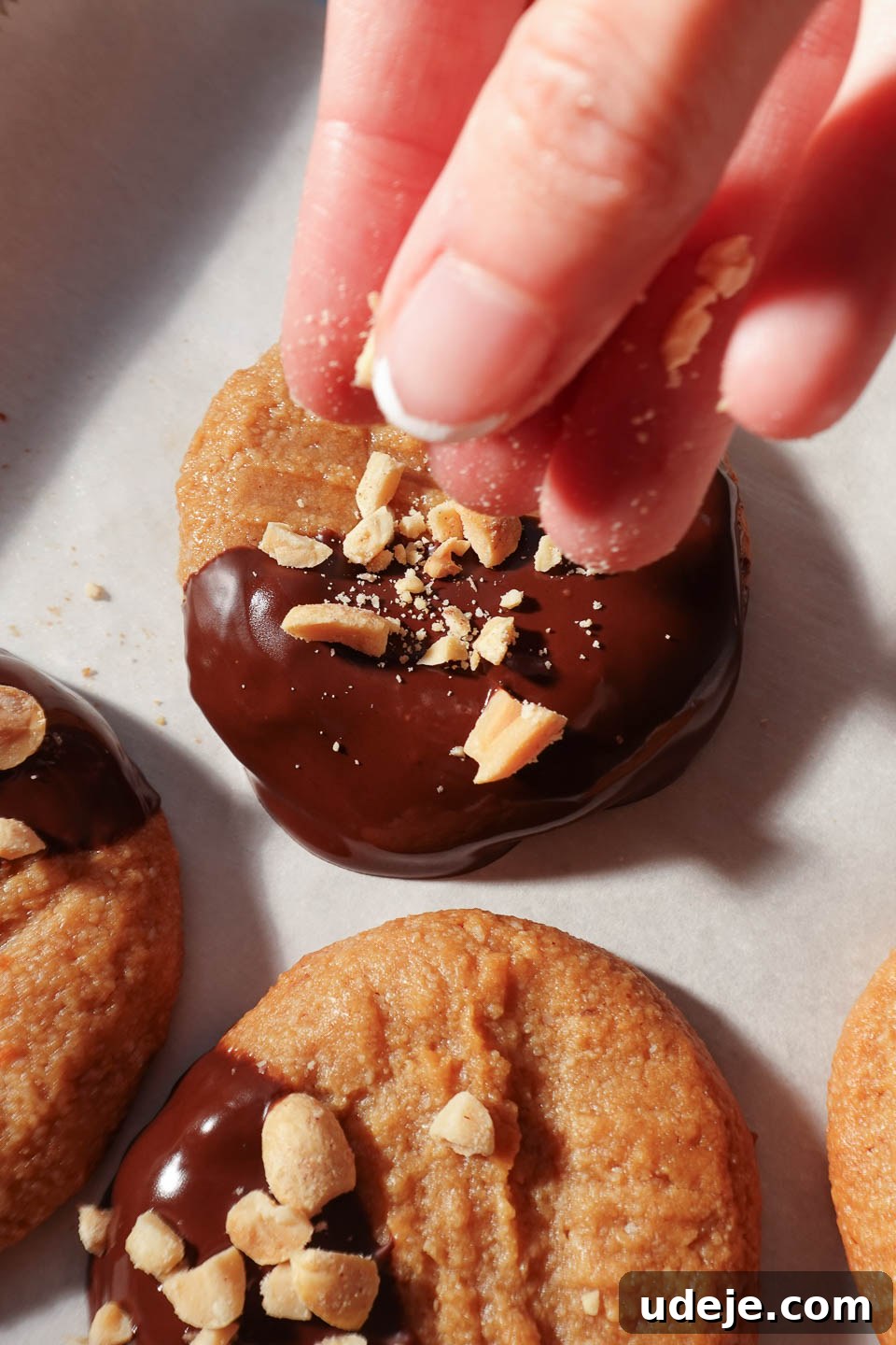 Simple Three Ingredient Vegan Gluten Free Peanut Butter Cookies 3 Sprinkling crushed peanuts on top of a peanut butter cookie for added crunch and flavor