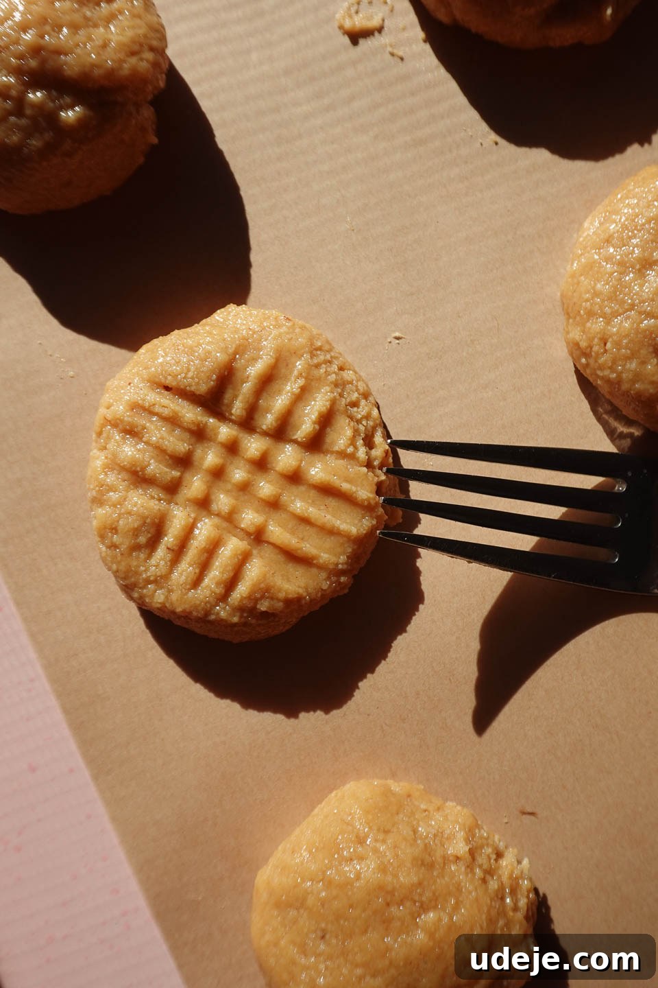 Simple Three Ingredient Vegan Gluten Free Peanut Butter Cookies 7 Using a fork to create the classic hatch pattern on peanut butter cookie dough balls before baking, ensuring even cooking and a signature look