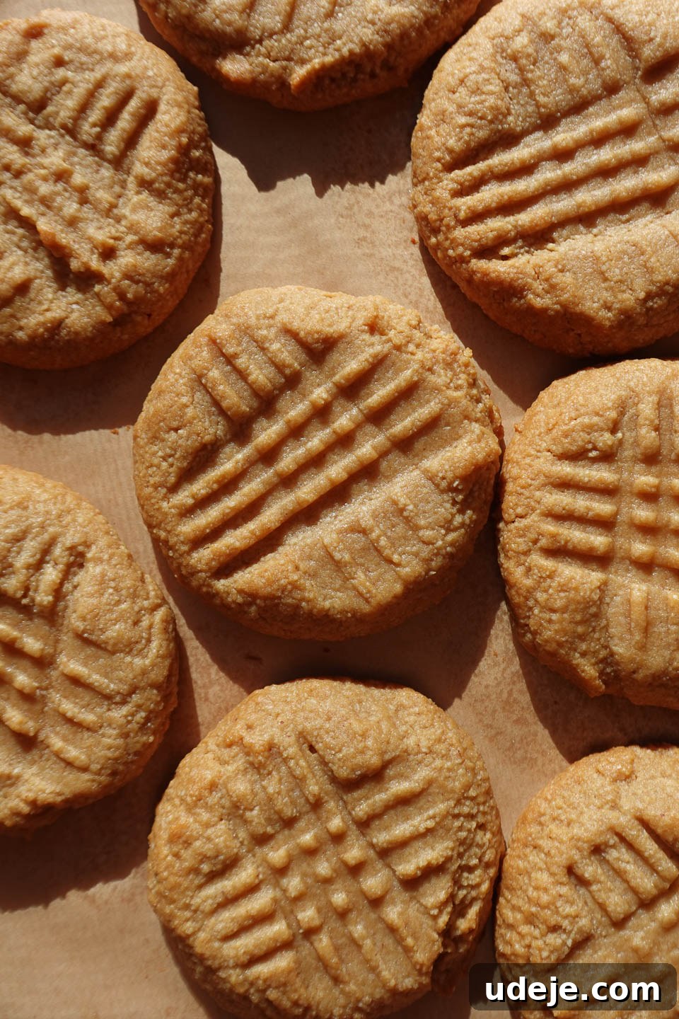 Simple Three Ingredient Vegan Gluten Free Peanut Butter Cookies 8 Freshly baked 3-ingredient peanut butter cookies resting on a baking sheet, showcasing their soft, chewy texture and golden edges