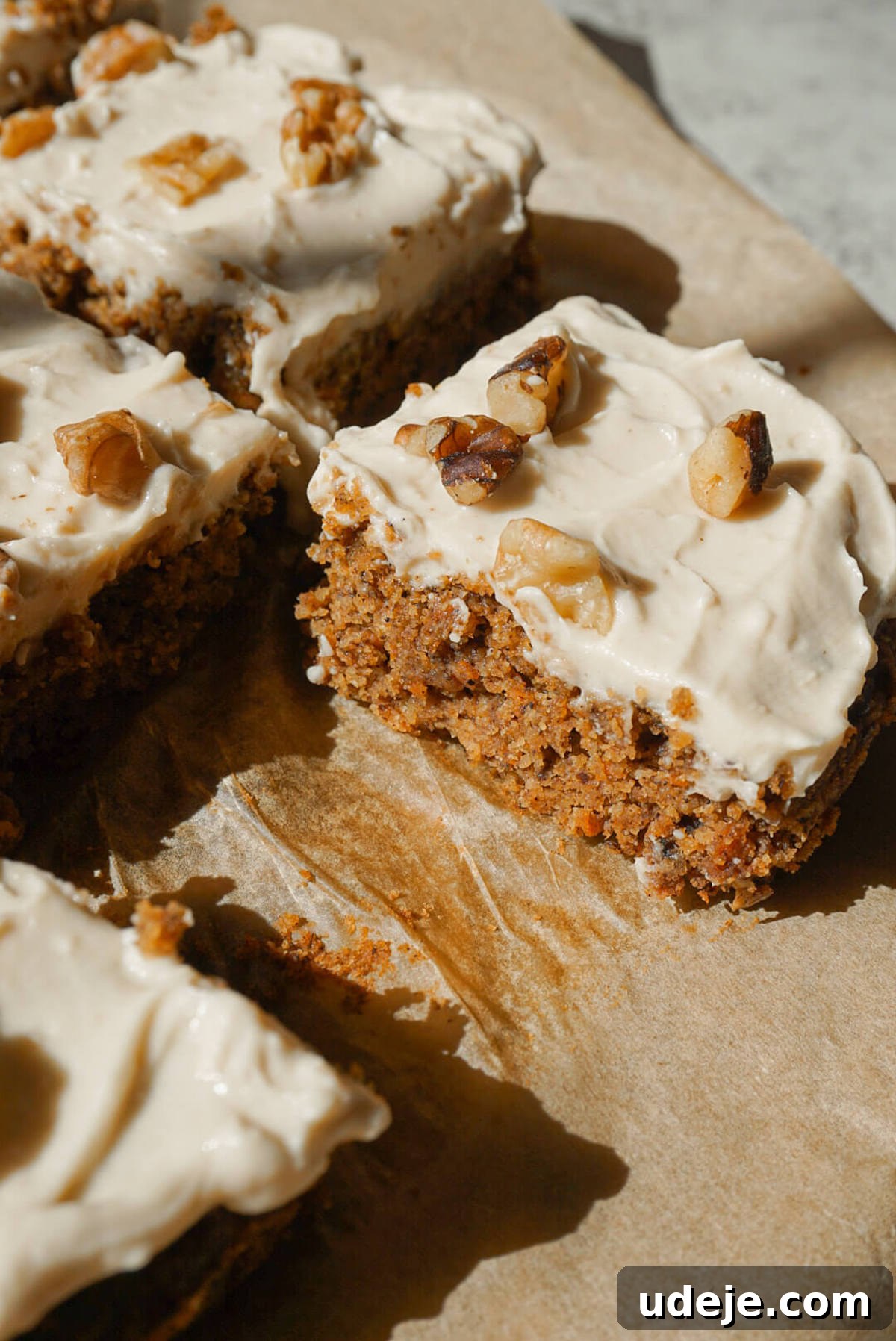 Wholesome Vegan Gluten Free Carrot Cake 4 healthy carrot cake sliced and topped with vegan cream cheese frosting and chopped walnuts showcasing it's moist and fluffy texture