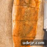 A glistening rainbow trout fillet, richly coated in an aromatic marinade, rests on a wooden cutting board, with a knife nearby, signaling it's ready for the next step of cooking.