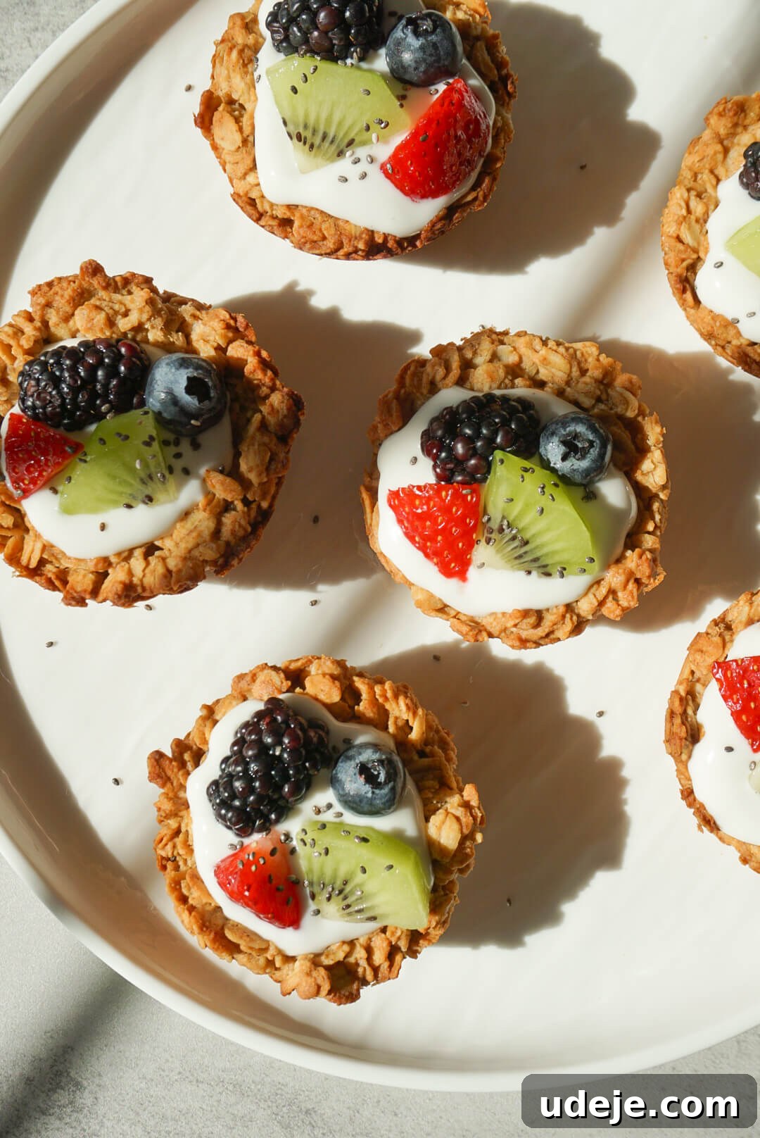 Effortless Granola Yogurt Treats 3 A close-up view of a single, vibrant granola yogurt cup, generously topped with an assortment of fresh berries like blueberries and blackberries, highlighting the texture of the granola base and creamy yogurt.
