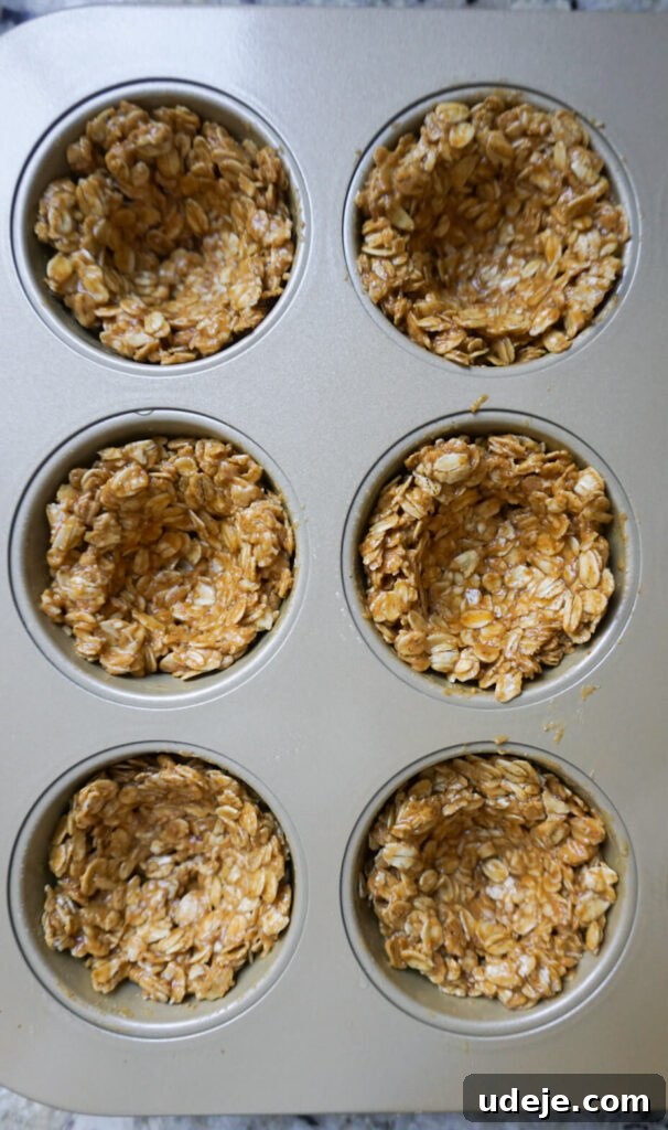 Effortless Granola Yogurt Treats 4 Close-up of the essential ingredients for granola cups: rolled oats, a jar of runny peanut butter, and a bottle of maple syrup, laid out on a clean kitchen counter.