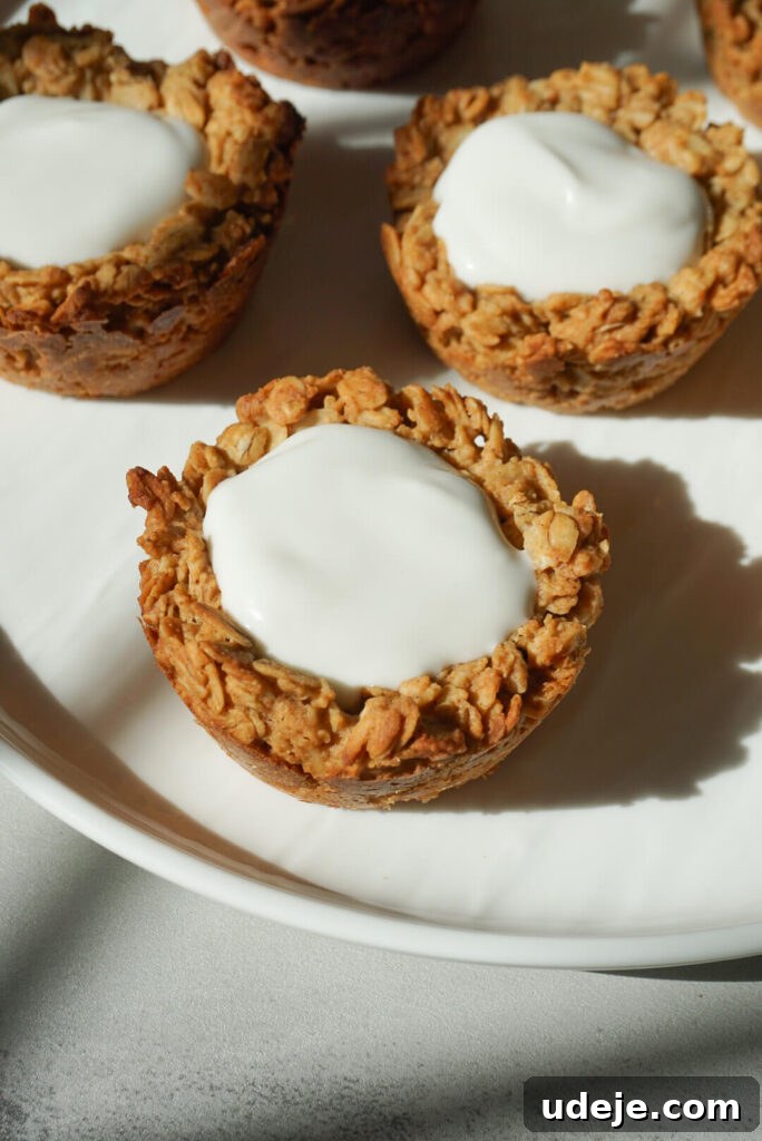 Effortless Granola Yogurt Treats 6 Baked granola cups cooling directly in the muffin pan after being removed from the oven, showing their golden-brown edges and firm structure.