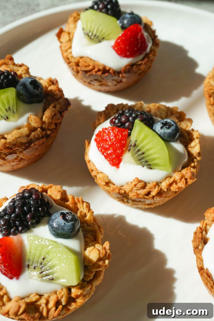 Effortless Granola Yogurt Treats 8 An overhead shot showcasing a variety of granola yogurt cups with different fruit toppings, including berries, kiwi, and passion fruit, emphasizing their colorful and healthy appeal.