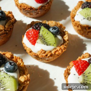 A beautifully presented bowl of freshly made granola yogurt cups, topped with a colorful array of fresh fruits and a sprinkle of chia seeds.