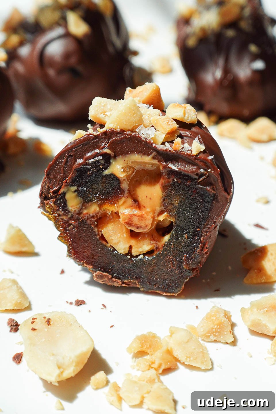 Snickers Date Bombs 4 Close-up of a gooey Snickers Stuffed Date, showing the rich peanut butter and chopped peanut filling inside the caramel-like Medjool date.