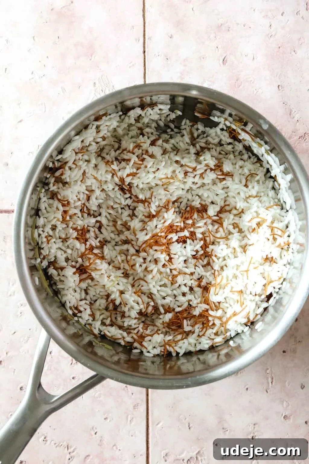Egyptian Cloud Rice 8 Vermicelli and Egyptian rice in a metal saucepan on a pink tiled background