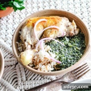 Molokhia: A Timeless Tradition 14 a beige bowl with rice, molokhia, cooked chicken and sliced red onions with a fork beside it on a woven background with molokhia in a white bowl in the corner, and cilantro in a bowl along with a salt shaker