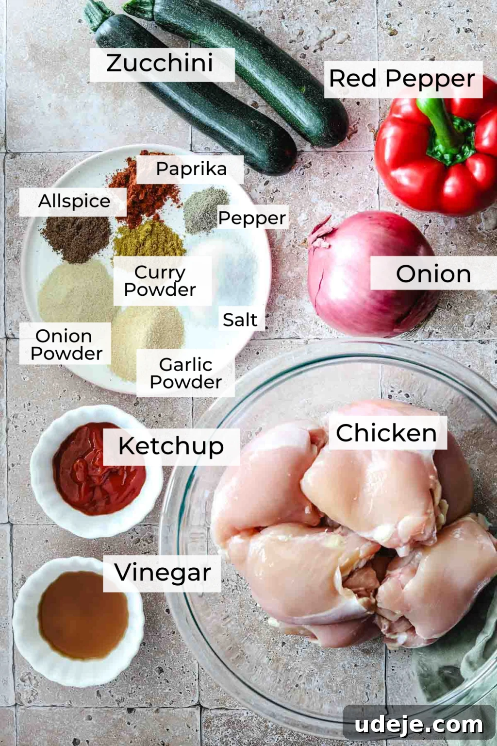 Effortless 15-Minute Air Fryer Chicken Skewers 6 A vibrant array of fresh ingredients for air fryer chicken kabobs, including neatly diced zucchini, red pepper, and red onion, alongside small dishes of paprika, black pepper, allspice, curry powder, salt, onion powder, garlic powder, ketchup, and vinegar. Boneless, skinless chicken thighs are ready in a glass bowl, all arranged on a rustic stone tiled background, highlighting the preparation for a flavorful meal.