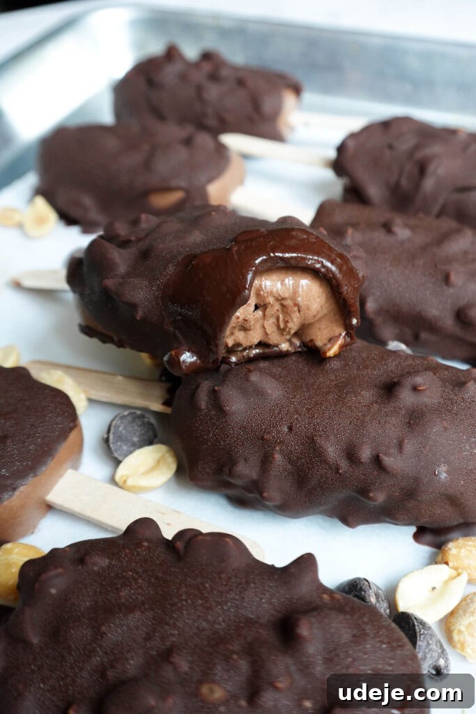 Choco-Crunch Vegan Frozen Bars 3 Close-up of a freshly made Vegan Chocolate Crunch Ice Cream Bar, showing the creamy interior and the thick, crunchy peanut chocolate coating.