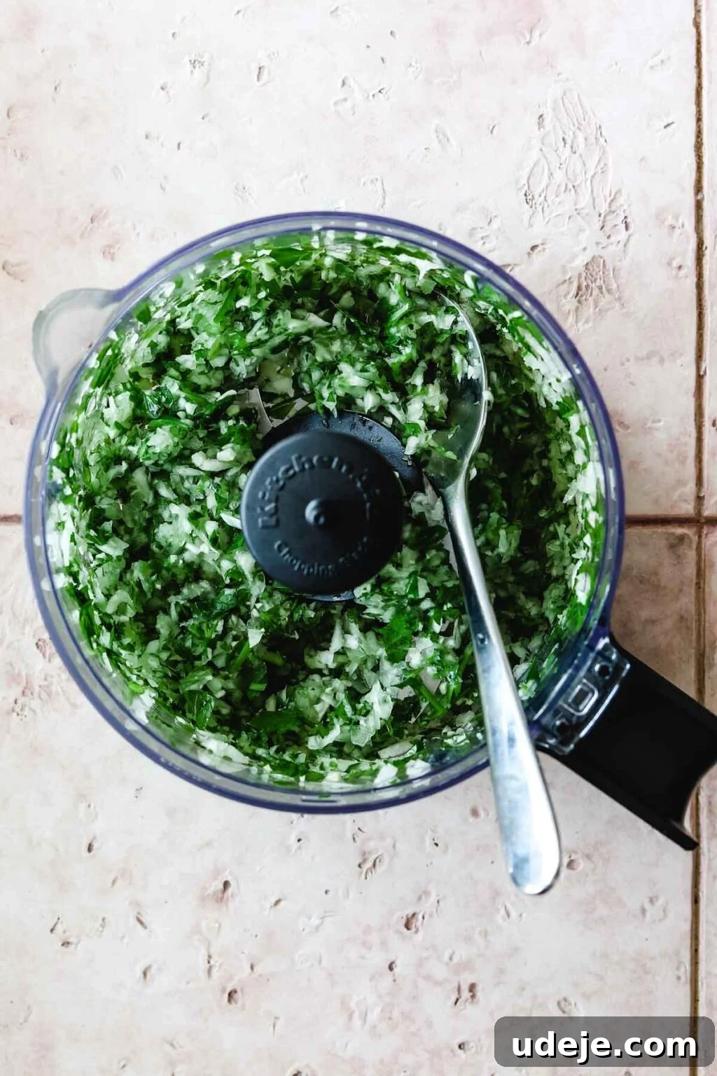 Speedy Chicken Kofta: Grill or Skillet in 20 Minutes 5 A small food processor containing finely chopped onions and parsley, with a metal spoon inside, ready for mixing.