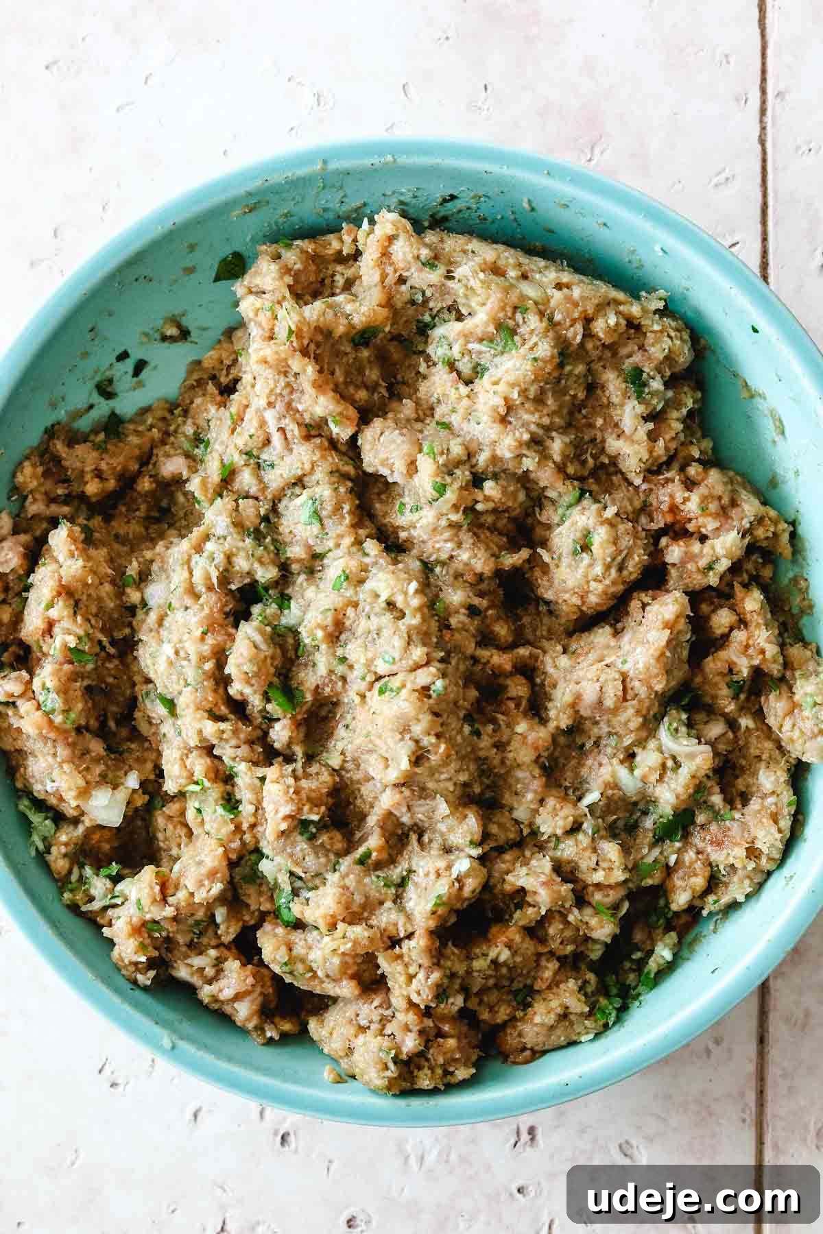 Speedy Chicken Kofta: Grill or Skillet in 20 Minutes 7 Uncooked ground chicken mixture, perfectly blended with spices, onions, and parsley, waiting to be shaped in a blue mixing bowl.