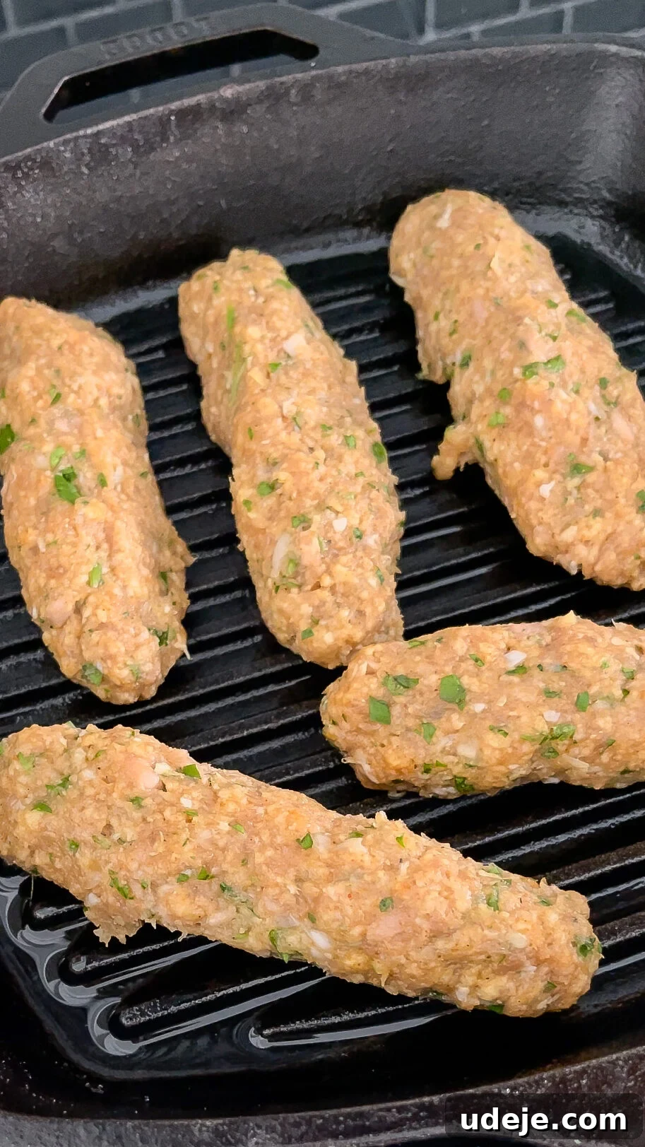 Speedy Chicken Kofta: Grill or Skillet in 20 Minutes 9 Raw chicken koftas, perfectly shaped into logs, sizzling on a hot cast iron grill pan, beginning to develop beautiful grill marks.
