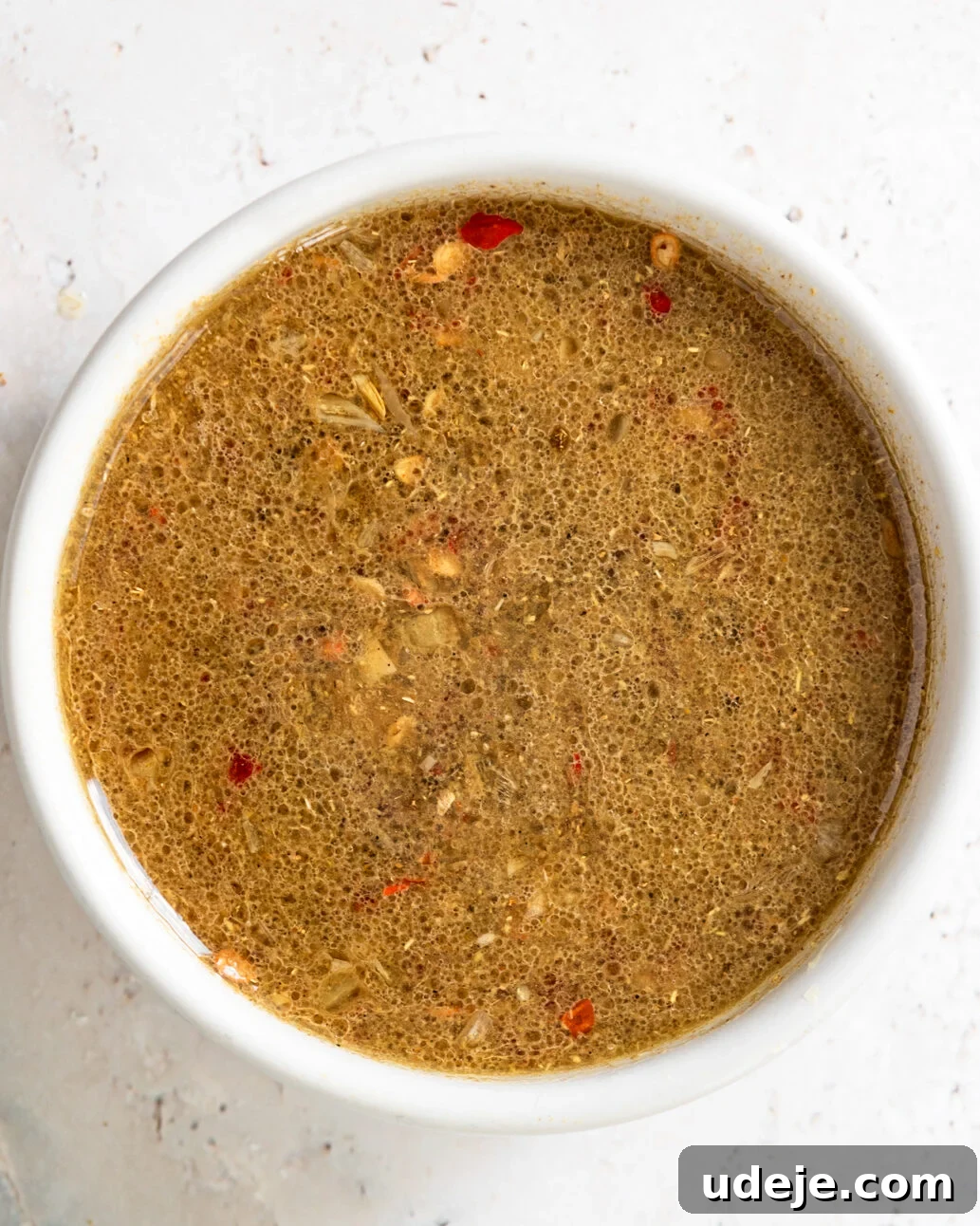 Egypt's Koshari: A Hearty Blend of Rice, Lentils and Pasta 18 dukkah in a small white bowl with a light green towel on a light grey marble background