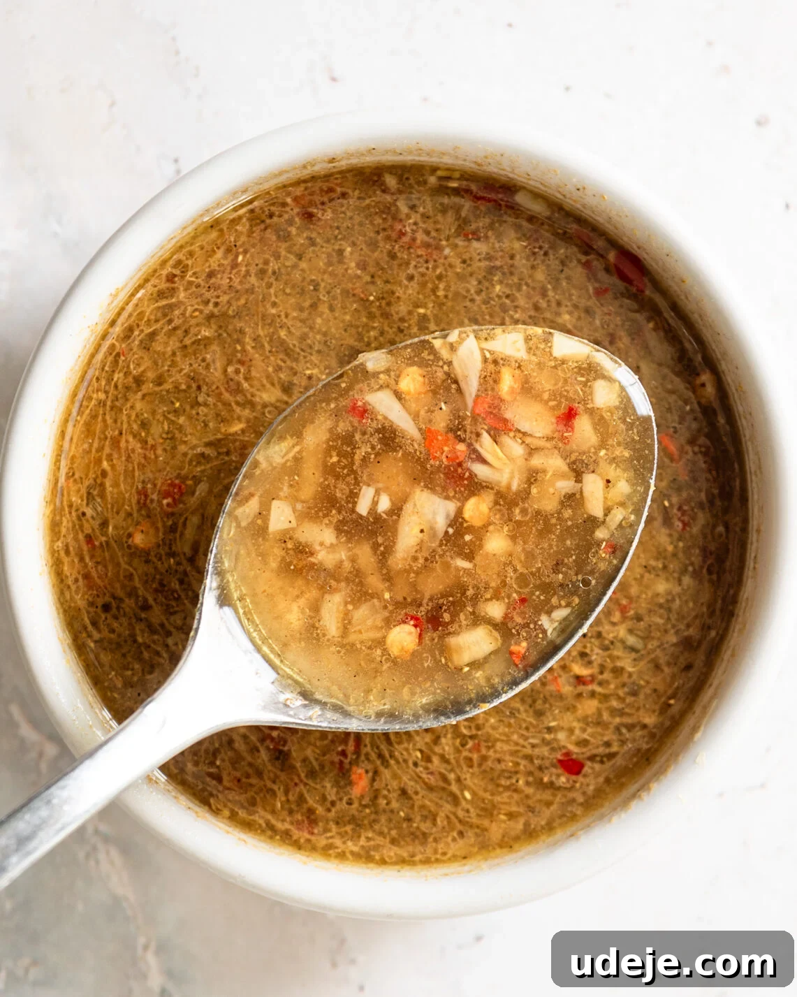 Egypt's Koshari: A Hearty Blend of Rice, Lentils and Pasta 19 dukkah on a spoon over a bowl of dukkah on a light grey marble background