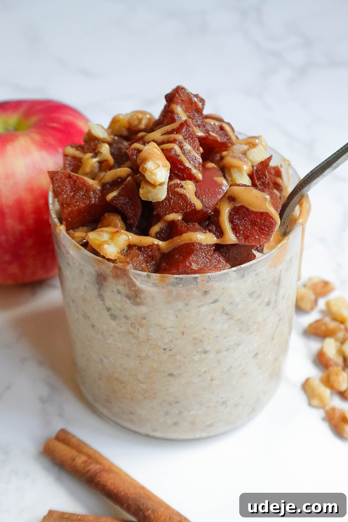 Spiced Apple Pie Overnight Oats 3 A close-up of the warm maple cinnamon apple topping, showing caramelized apple pieces infused with spices, ready to be spooned over overnight oats.