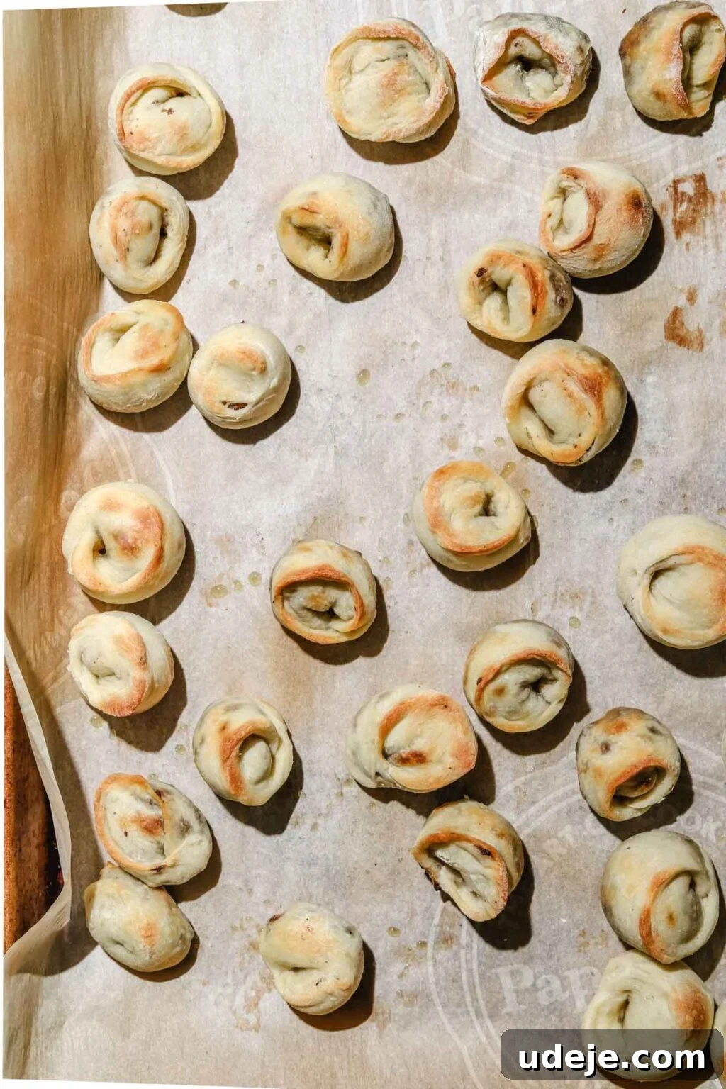 Mastering Homemade Shish Barak: Authentic Yogurt Dumplings 17 Lightly browned Shish Barak dumplings on a parchment-lined baking sheet, freshly baked to perfection.