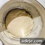 Shish barak dough in metal stand mixer bowl on a light marble background