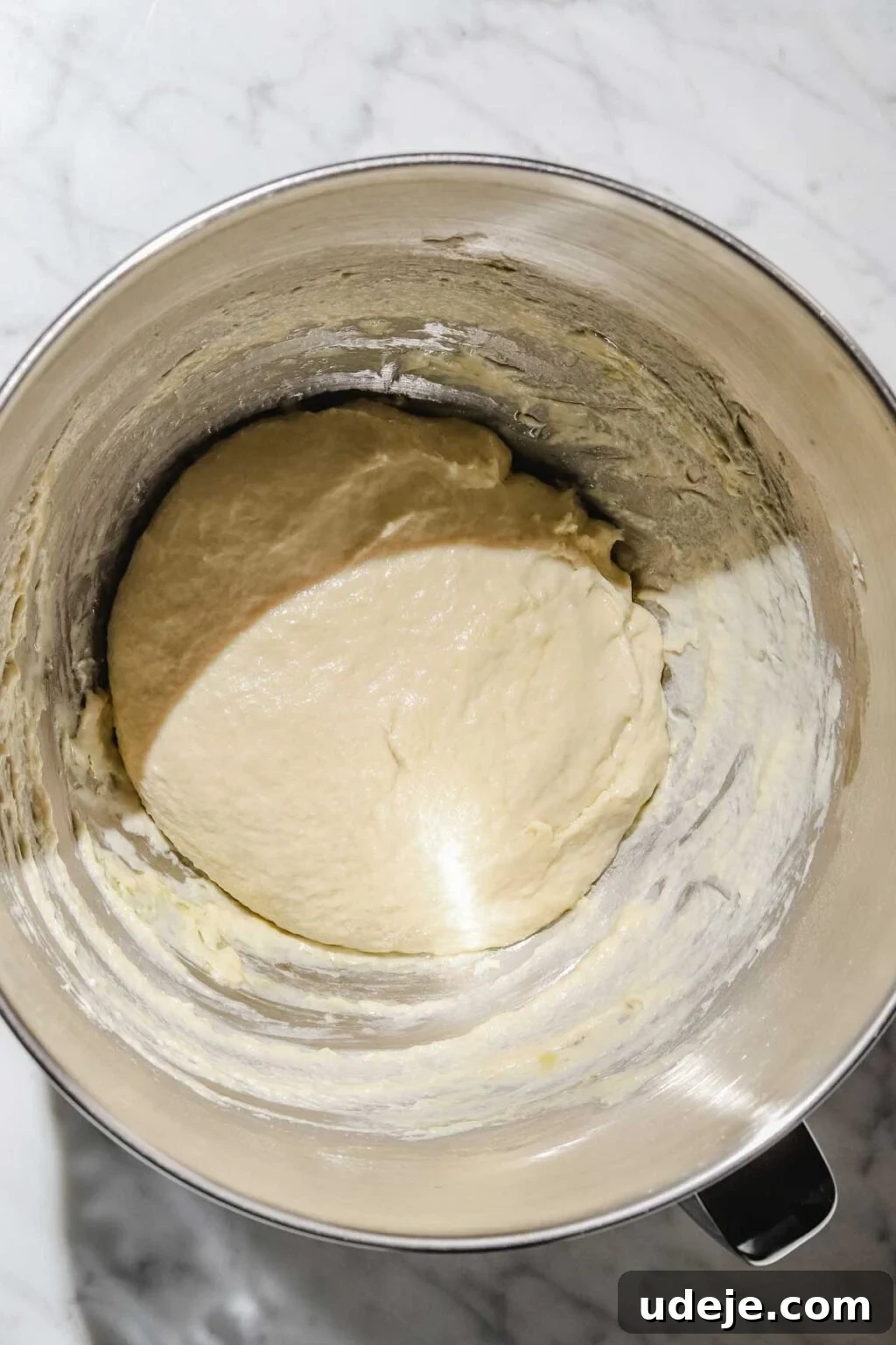 Mastering Homemade Shish Barak: Authentic Yogurt Dumplings 5 Smooth Shish Barak dough resting in a metal stand mixer bowl on a light marble background, covered for its resting period.