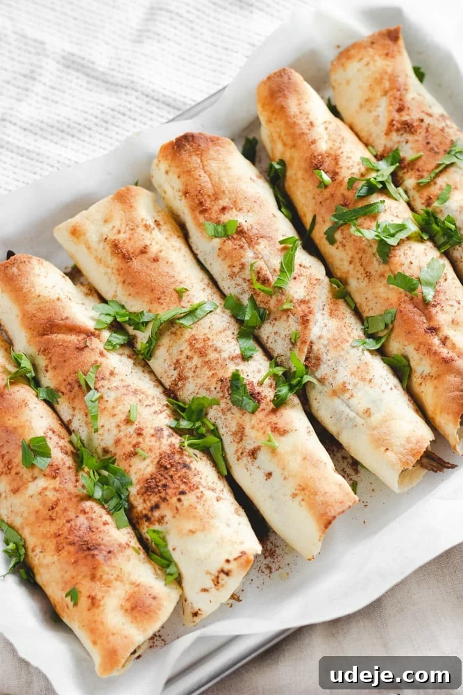 Sumac-Spiced Chicken Musakhan Crisps 20 Pita bread rolls served on a parchment lined tray, garnished with fresh parsley, a delightful and easy variation of Musakhan.