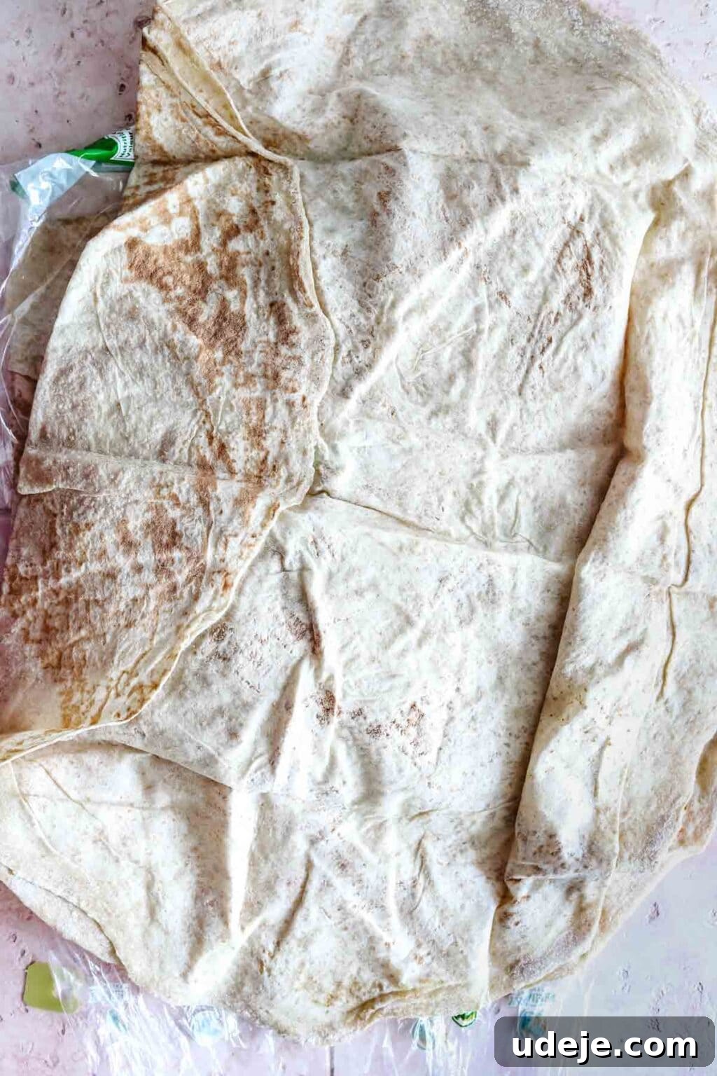 Sumac-Spiced Chicken Musakhan Crisps 4 Markouk bread, thin and pliable, on a light coloured background