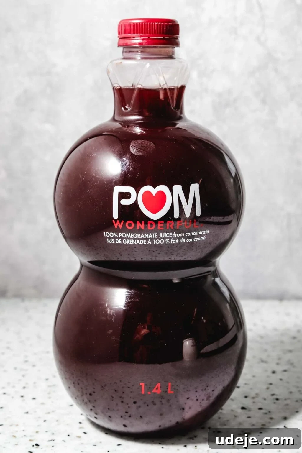 Homemade Pomegranate Molasses: Sweet, Tangy, and Versatile 6 Pom Wonderful 1.4L juice bottle on a speckled background