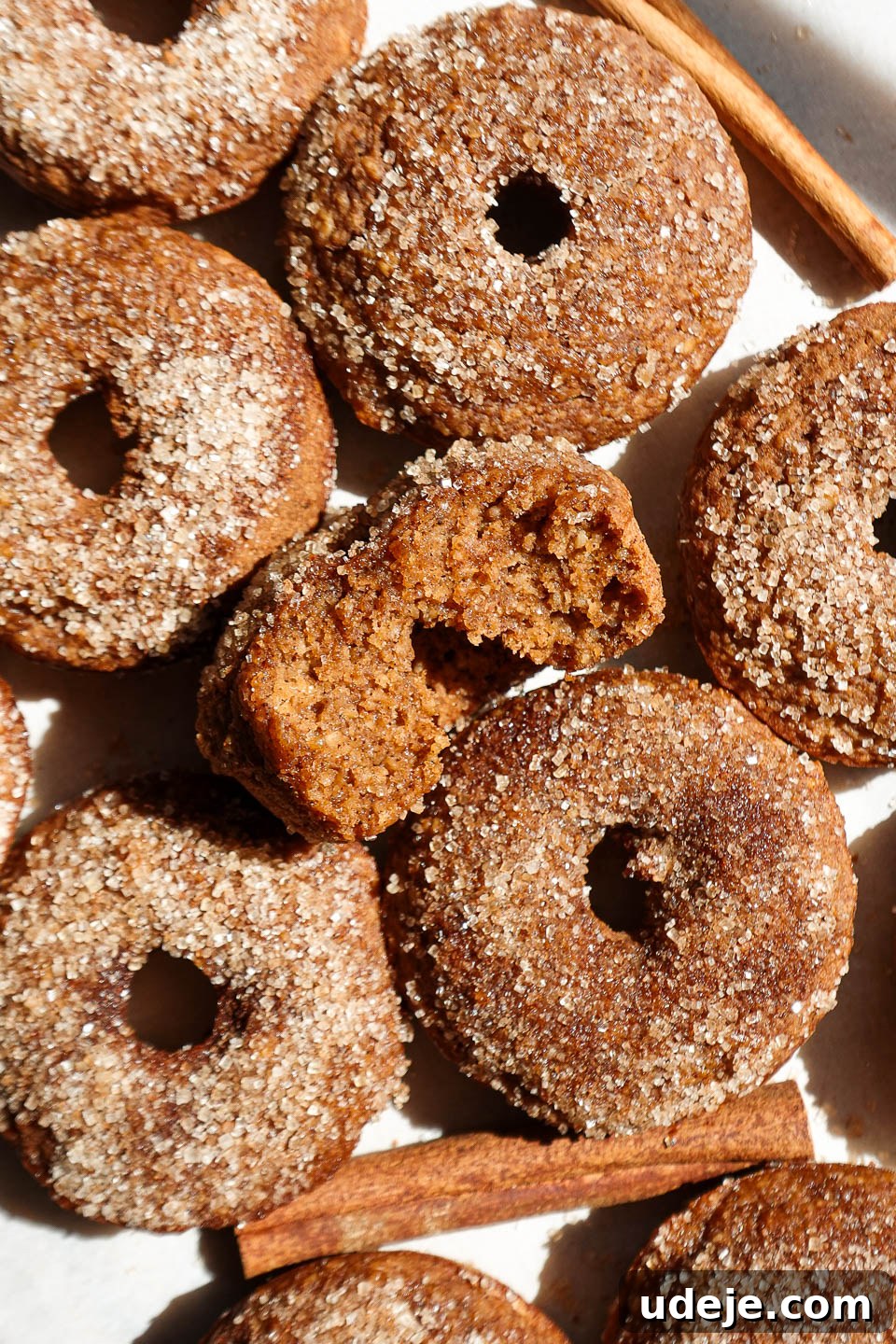 Wholesome Baked Apple Cider Doughnuts 2 Baked apple cider donuts coated in cinnamon sugar on a plate