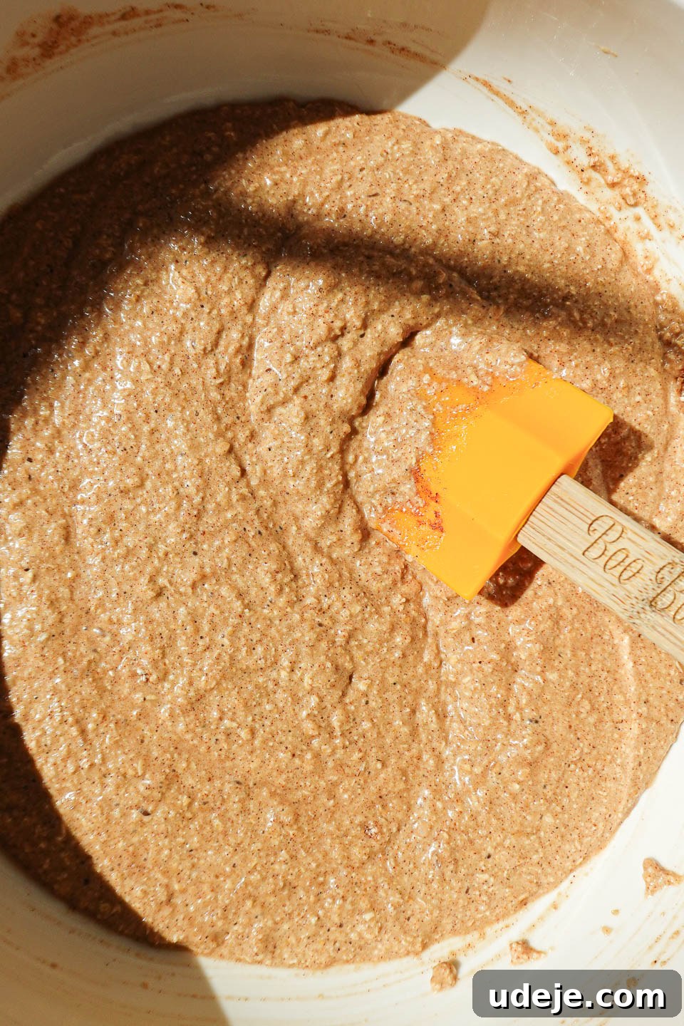 Wholesome Baked Apple Cider Doughnuts 5 Whisking vegan apple cider donut batter with oat flour and applesauce in a mixing bowl