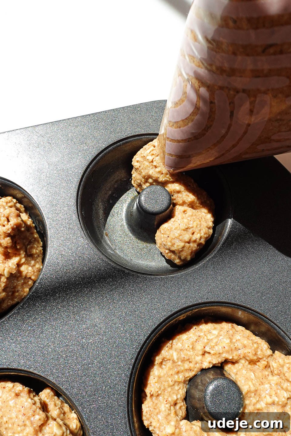 Wholesome Baked Apple Cider Doughnuts 6 Piping apple cider donut batter into a mini donut pan